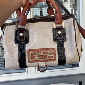 Äkta guess väska - En glansig guess väska med krokodil skin och har även ett längre band som man kan ha över axeln ! Orginalpris : 1000kr, Jävligt bra kap!! 