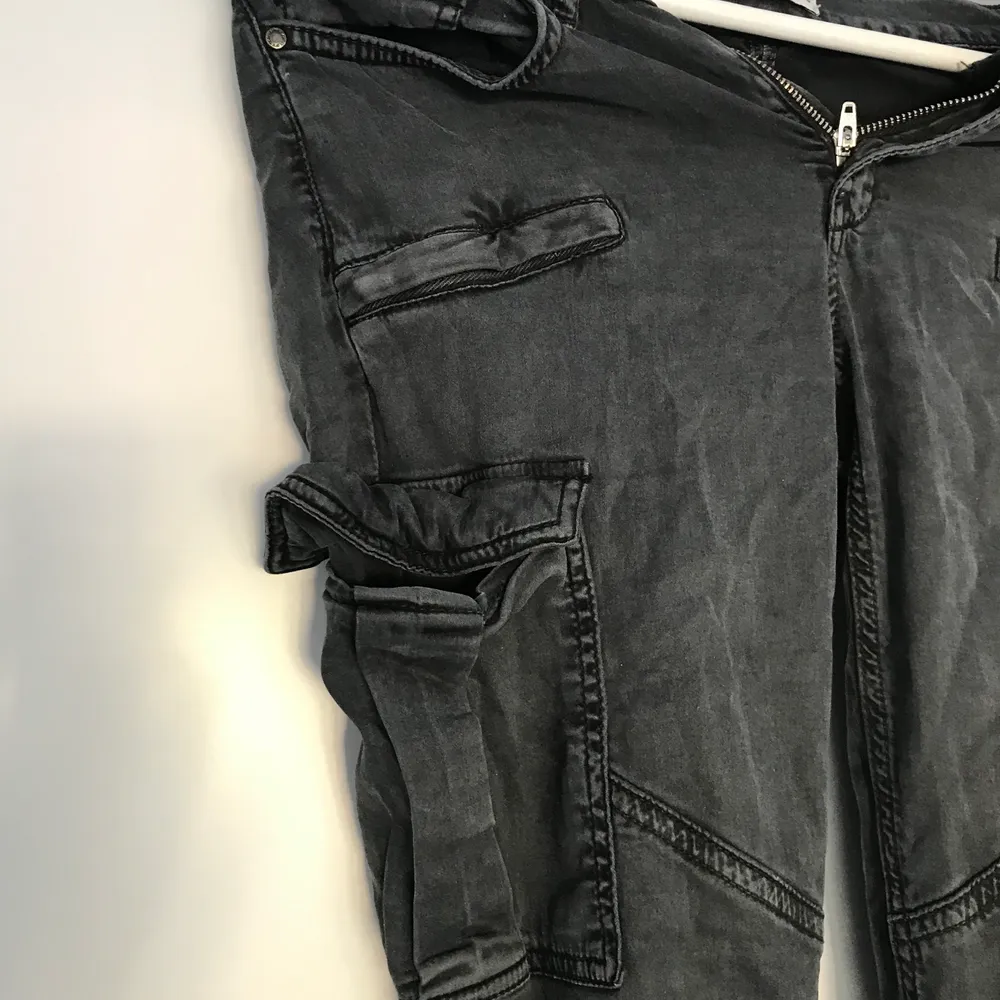 Ett par mörk grå cargo byxor från Gina tricot med en ficka på höger ben. Säljer för de inte kommer till användning. Köpare står för frakten.. Jeans & Byxor.