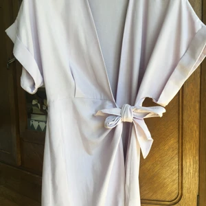 & Other Stories lila klänning  - Kort omlottklänning med knyt från & Other stories, mycket skönt och svalt material! Har burit den en gång sedan jag köpte den! Färgen är syrenlila/lavendel, som på bild nr 2. Ord. pris 790 kr