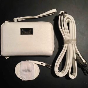  - Säljer min Lissa Wang universal hand/axelremsväska i färgen vit croc. Väska med innerfack för mobilen, 3st kortfack och fack för sedlar. Avtagbar handledsrem, bred axelrem och smal axelrem. Aldrig använd, fått en liten fläck därav priset. Nypris: 199 kr