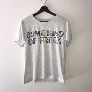  - Ljus grå T-shirt med färgglatt tryck på framsida bröst. Köpt från Monki och använd ett fåtal gånger. Storleken är S men passar även för storlek M. Skönt material i 98% bomull och 2% viskos. Betalning sker vis Swish och köparen står för frakten. 