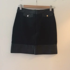  - Kort svart kjol med skin (fake) detaljer 
