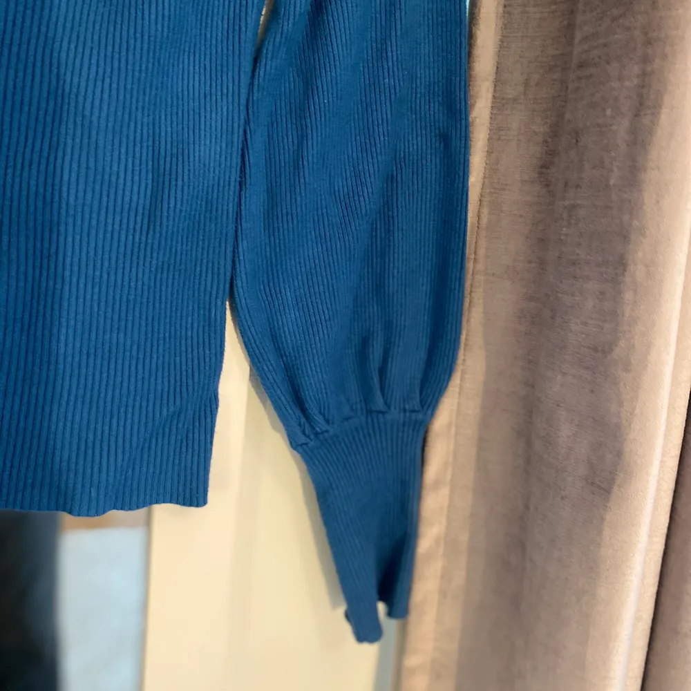 Fin blå tröja från Gina Tricot med bred urringning och volangärmar, bra skick!. Stickat.