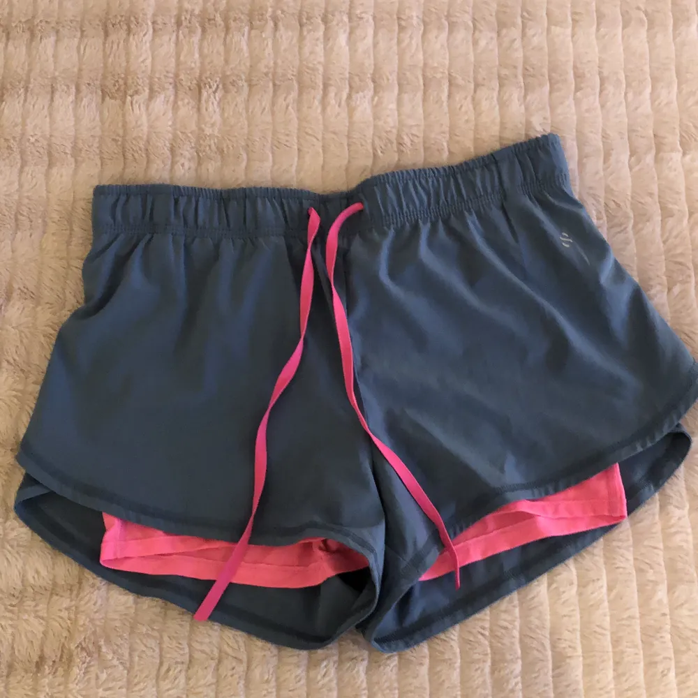 Gråblåa träningsshorts med rosa under från H&M. Sjukt sköna att träna i och sitter väldigt bra, samt är i gott skick. Säljer pga för små för mig.. Shorts.