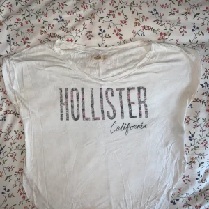 Topp - Kortärmad topp från Hollister med text framtill i jätteskönt tyg. Avrundad form, söm längs ryggen och uppvikta ärmar. God kvalitet. Skriv för fler bilder. Möts upp i Falun eller skickar om du betalar frakten✌🏻 