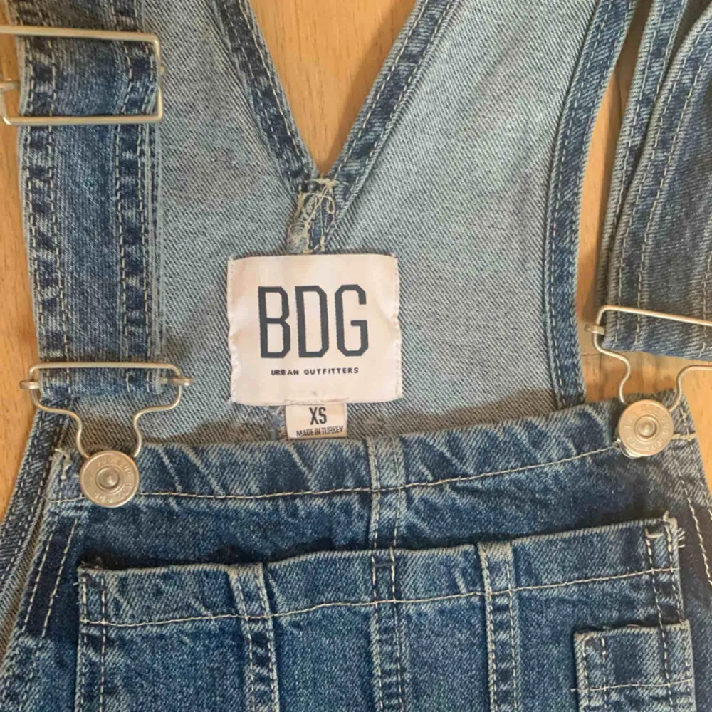 Säljer denna urgulliga jeans hängselkjol från Urban outfitters jeansmärke BDG, då den aldrig kommit till användning. Så fin med kanske en polotröja under, eller något liknande. Strlk XS men passar lätt en S.. Kjolar.
