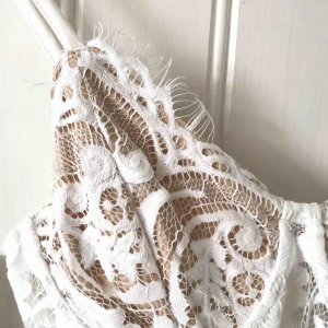  - Vit body i romantisk spets från Fashion Nova. Ovadderad kupa med bygel, dragkedja i ryggen samt knappar nertill. Aldrig använd så i nyskick. Köparen står för frakten 🕊