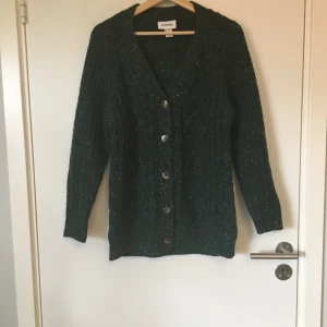 Stickad kofta från Monki - Mörkgrön stickad kofta från Monki. Stl XS. Gott skick. Frakt betalas av köparen.