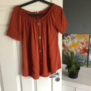 Topp - Snygg orange/brun topp i storlek xs (passar både S och M) använd en gång! Porto 44kr 