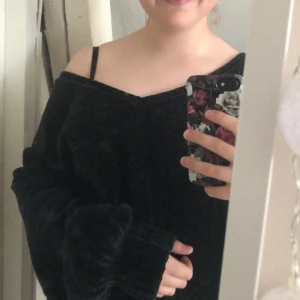 Manchester tröja, stickad - Oversized tröja i Manchester/velour stil. V-ringad i ryggen och rund framtill, men är lika snygg att vända och ha bak och fram. Köpt på bikbok för kanske 3 år sen. Svart men skiftar i blågrönt 