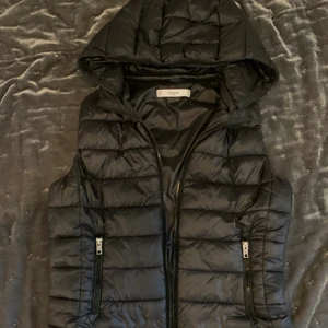 Väst från mango - Snygg svart väst från mango, i storlek M. Luvan går att ta av. Pris 200kr