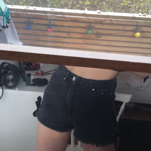 Svarta shorts - Ett par svarta shorts med detaljer på båda sidorna. Knappt använda så bra skick. Ifrån Primark i London. Strl 34 (S).