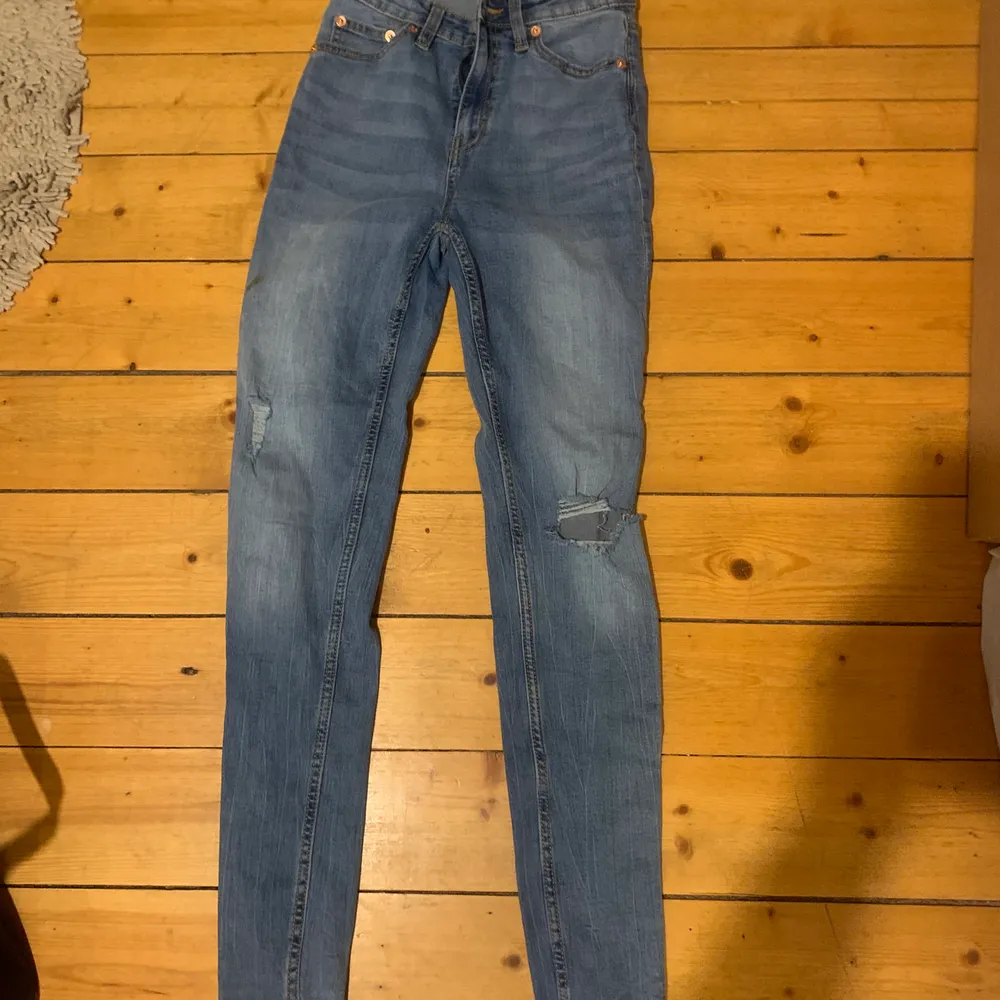 jeans med hål på ena knät och slitning på andra benet. storlek xs men skulle kunna passa s. Jeans & Byxor.