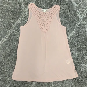 Ljus rosa linne  - Ljus rosa linne med snygg detalj längst med halsen. 