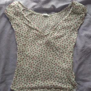 Mini topp  - En väldigt söt topp i transparent typ, små somriga blommor och sitter perfekt. stretchigt tyg så passar xs-m. Lätt puffig på axeln.