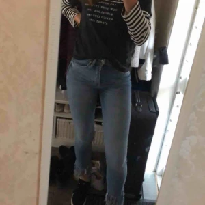  - Ett par blåa jeans med detaljer nedtill 