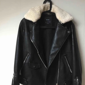 Bikerjacka med pilekrage - Snygg oanvänd jacka från Bershka. Biker-modell med dragkedja i ärmar och avtagbar pilékrage. Ej skinn. Snygg till allt! Katt finns i hemmet