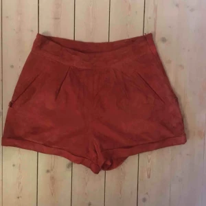  - Röda mocka-shorts från TopShop. Snygga till t. ex vitt linne. Skick: SLITNA. Dragkedjan trög och shortsen sett bättre dagar. Köpt på myrorna i Stockholm i samma skick. Dock 100% läder på utsidan och sjukt coola shorts, och priset ⤵️