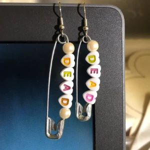 supergulliga örhängen!! - örhängen gjorda av pärlor och säkerhetsnålar med ordet ’dead’ <3 frakt tillkommer med 11kr