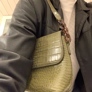 Krokodilmönstrad väska - Baguette väska från Pimkie köpt i Palma, säljer pga används för lite. Coola detaljer på bandet :) säljer för 80kr + frakt 