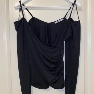 Festlig topp - Snygg, enkel och festlig topp från gina tricot. Offshoulde med smala axelband. Sitter tajt och snyggt. Storlek S