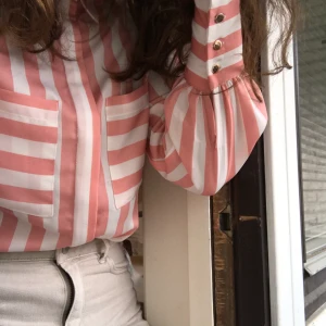 Randig skjorta - FINASTE rosa/vit randiga skjortan från Vila. Använd ca 2 gånger. Simpel och stilren men ändå unik. Sitter guldknappar på ärmarna och längst upp vid kragen (bild 3) - några av dem är skavda, inget man tänker på men kan skicka bild om så önskas💕💞🦋