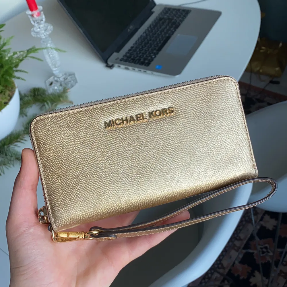 Säljer min MK plånbok som jag endast använt en gång. Funkar perfekt till bal, minimalistisk stil med guld/glittrig färg som ger en bling-touch. Får plats med en mobil + kort.. Väskor.