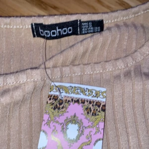 En helt oanvänd booho tröja med prislapp. - Det är en booho tröja med en rosett som man kan sjustera på egen hand! Prislappen är på. Ord priset 250kr omvandlat pris 80kr(köpare står för frakt)