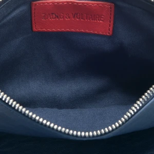 Zadig Voltaire Väska  - Jag säljer min mörkblå Zadig väska med röda detaljer. Väskan säljs ej längre och är sällsynt. Ny pris:4000kr jag säljer för 3000kr(pris går att diskuteras). Väskan är i mycket bra skick. Både lång och kort kedja tillkommer samt dustbag. Fler bilder kommer