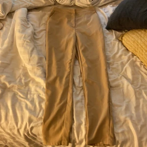 Kostymbyxor 34 - En beige kostymbyxor från nakd storlek 34, använd 1-2 ggn. Lite för stora för mig, frakten ingår☺️