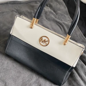 Michael kors väska - Michael Kors väska i svart och vitt. Ej äkta men supersnygg och i superbra skick! Osäker om jag ska sälja den så buda i kommentarerna. 250kr och uppåt🌸 frakt tillkommer på 150kr