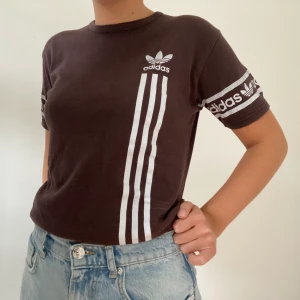 Brun adidas t-shirt - Brun t-shirt från adidas i strl L. Men liten i storleken, sitter som en S. Använd men i bra skick. Säljer för 40 kr + frakt.