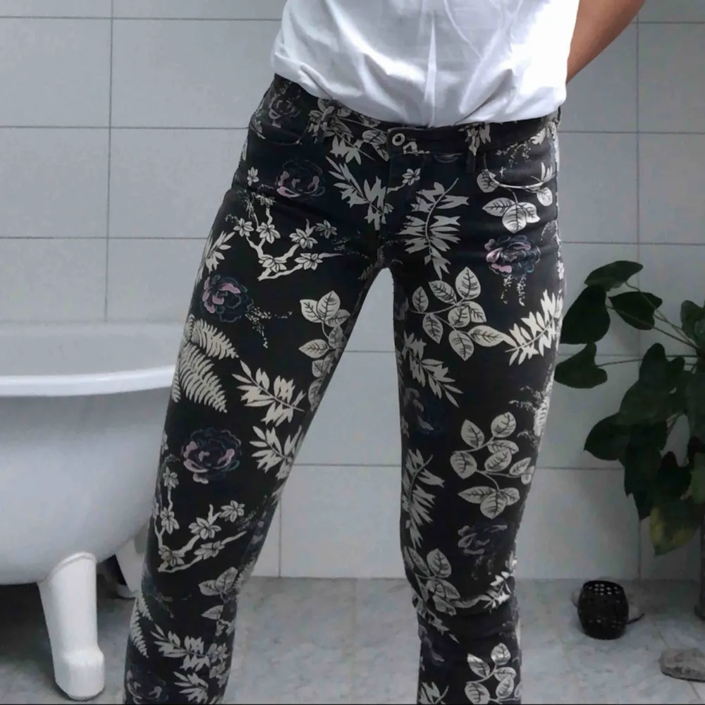 Ett par gråa jeans från Levis med blom- och lövmönster. Snygga till en vit t-shirt! Modellen är stretch så de passar både S och M. Jeans & Byxor.