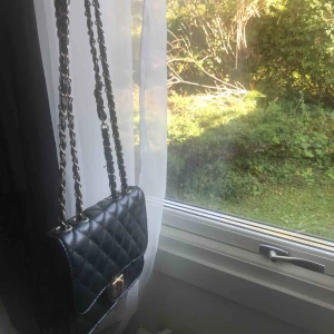  - svart liten väska med guldiga detaljer. går att ha både långt och kort band. har två fack med dragkedja! köparen står för frakten