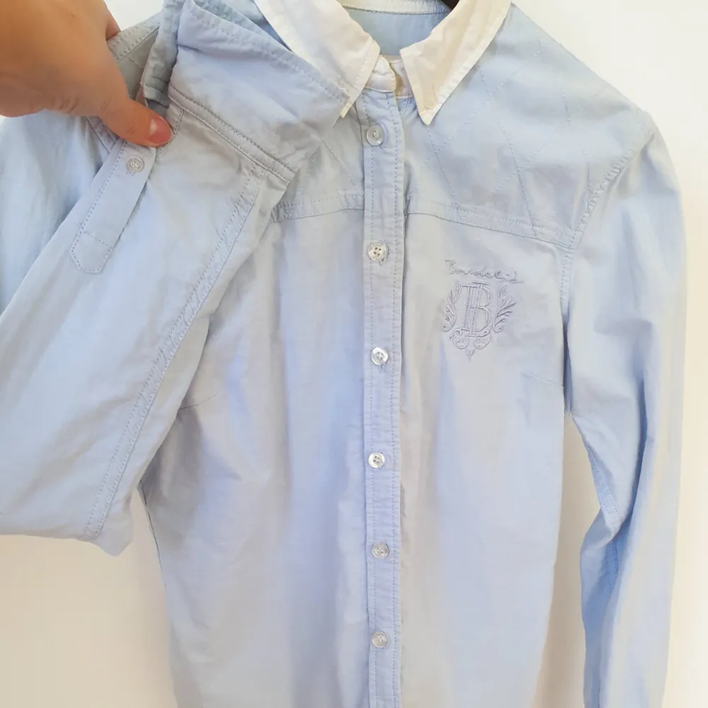 Ljusblå skjorta från Bondelid, MQ.  Fint skick med härliga detaljer.  Skjortan är i forgursydd. Kan mötas upp i Huddinge, Älvsjö, Årsta, Globen & Västberga . Skjortor.