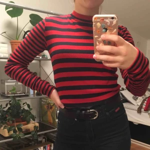  - En långärmad tröja från Superdry. Lite räfflat tyg med svarta och röda ränder. Liten polokrage. Priset är inkluderat frakt.
