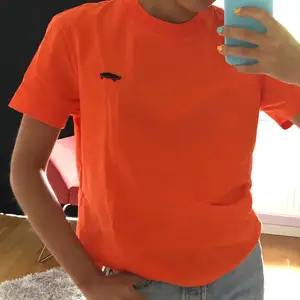 Cool stark orange T-shirt med litet skateboardtryck på. Starkt och bra kvalite på tyget som har svårt att bli skrynkligt. Sitter som en vanlig T-shirt. Bra skick!
