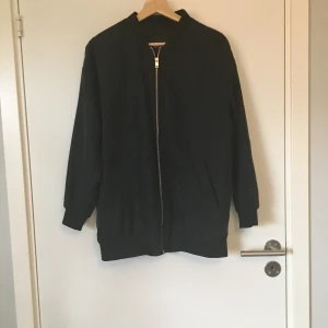 Lång bomberjacka i svart från Monki - Lång bomberjacka i svart från Monki. Stl XS. Gott skick. Frakt betalas av köparen.