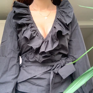 Snygg svart topp - Fin tröja med volanger, jättefin på fest. Helt ny, lappar kvar. Storlek S