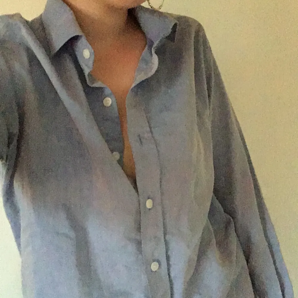 Superfin ljusblå skjorta i lite glansigt material. Perfekt till sommaren! Jag har vanligtvis XS/S i tröjor och denna är perfekt oversized! Den är i bra skick!. Skjortor.