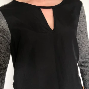 Gråsvart topp - Topp med grå baksida och svart framsida. Mycket fint skick. Kan hämtas i Malmö, är lite osäker på exakt fraktkostnad.