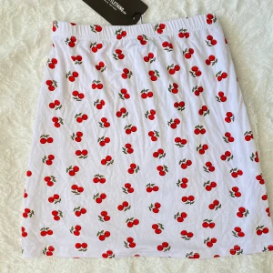 Jätte gullig minikjol från PLT - Oanvänd vit minikjol med körsbär på! Står 42 men passar mig som brukar ha 38, och sitter fortfarande lite tajtare än vad jag skulle önska. 