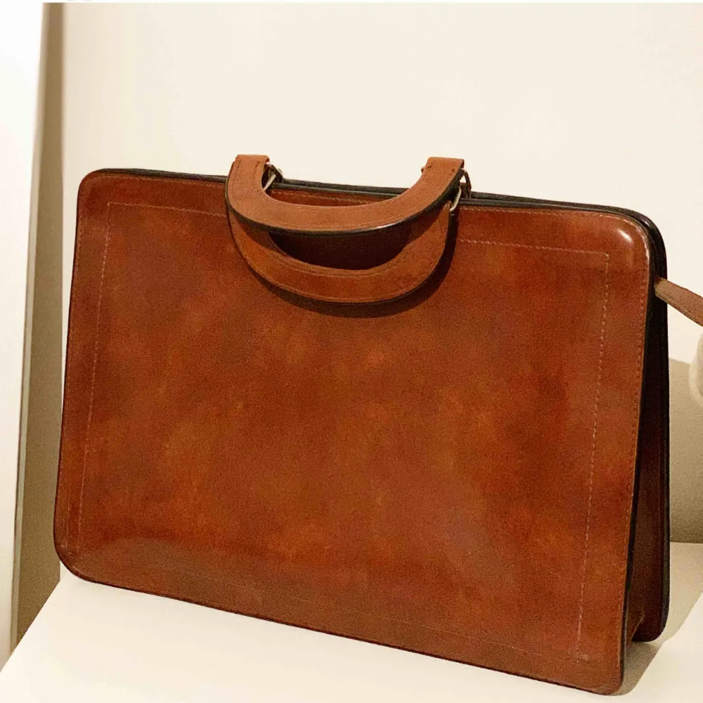 Snygg väska perfekt för dator i brun skinn imitation. Köpt på secondhand. . Väskor.
