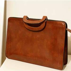 Snygg väska perfekt för dator i brun skinn imitation. Köpt på secondhand. 