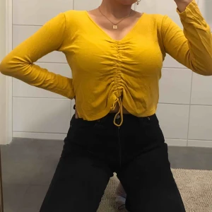  - jättefin gul blus som inte används längre. justerbar med band. ribbad. frakt tillkommer