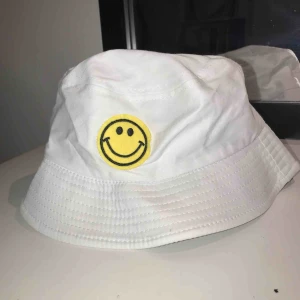  - Fiskehatt med gul smileys. Aldrig använd