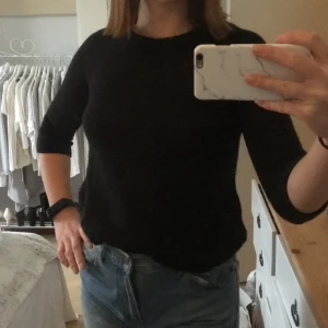 Svart stickad tröja  - Väldigt fin stickad tröja i svart, med detalj på ryggen. Den är stickig i materialet, men annars väldigt skön 