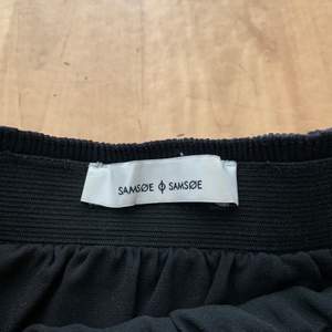 Plisserad utsvängd svart kjol från Samsoe Samsoe, storlek XS. Aldrig använd så i fint skick! Kan mötas i Stockholm eller skickas mot fraktkostnad 