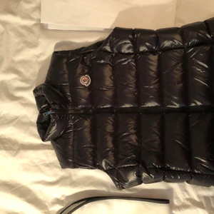 Moncler väst  - Västen e knappt använt köptes i maj, är i väldigt fint skick, kvitto finns samt allt de som ingår, det är 2 års garanti på västen. 