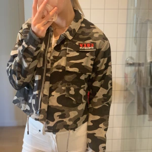 Droppas militärjacka från h&m - Militärjacka med röda tryck både fram och bak